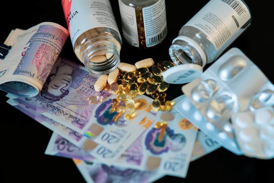 The image displays a collection of medication bottles, which are mostly lying on their sides with some caps still attached, revealing the open mouth of the containers. The bottles are made of transparent or opaque plastic, with labels featuring printed text and barcodes, though the writing is not legible in the image. Surrounding the bottles are various pills and capsules, including elongated, oval-shaped tablets in shades of white and beige, and small, shiny, gold-colored capsules or gel caps, some scattered directly on the surface and others near the bottles. The scene appears to be set on a dark surface, offering a stark contrast to the light-colored pills and bottles, with a soft, even lighting that highlights the textures—smooth, shiny capsules and matte tablet surfaces. The overall composition suggests a disposal or clearing process related to pharmaceuticals, aligning with services offered by Waste Disposal Harringay for managing unwanted or expired medication waste, illustrating the importance of proper disposal in compliance with waste management standards.